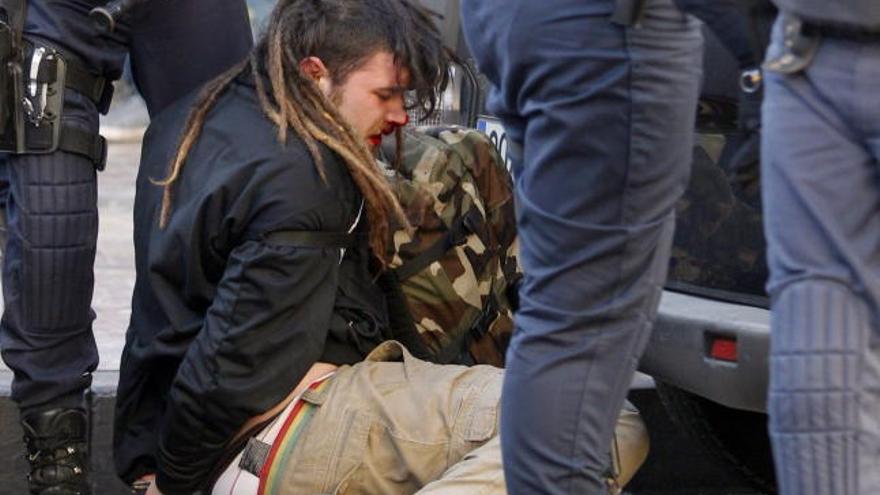 La policía custodia a un detenido durante los incidentes entre estudiantes y policias registrados hoy en el centro de Valencia.