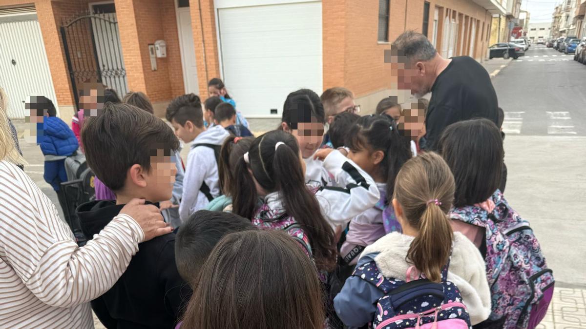 Niños y niñas esperan el autobús escolar en Beniparrell para ir al centro al que estan desplazados en Silla.