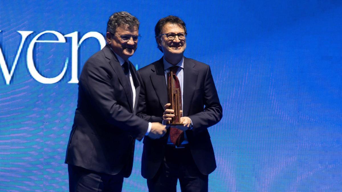 El director de INFORMACIÓN, Toni Cabot, entrega el «Importante» a Carlos Benavent, propietario del comercio.