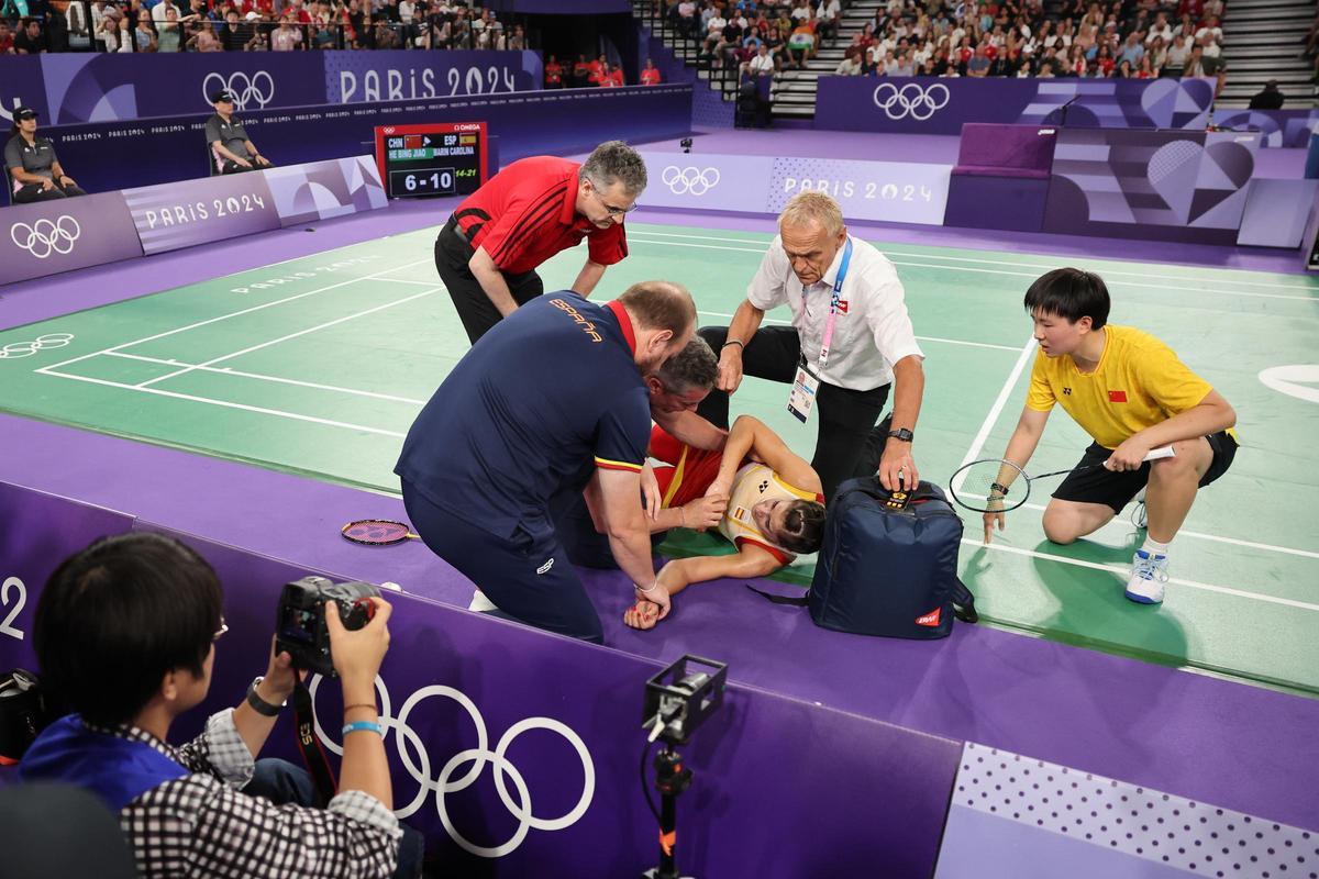 La jugadora española Carolina Marín es atendida por su equipo tras sufrir una lesión durante su partido de semifinales de bádminton femenino individual de los Juegos Olímpicos de París contra la china Bing Jiao He en el pabellón a Chapelle Arena este domingo en la capital francesa.