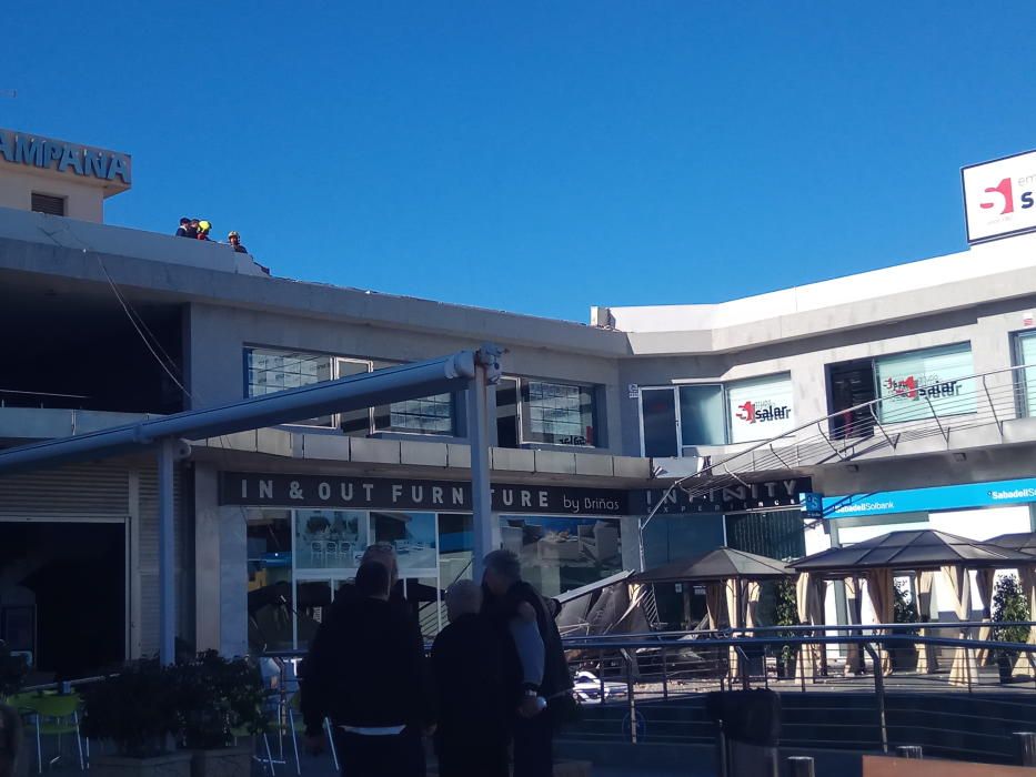El viento derriba un cartel de grandes dimensiones sobre la terraza de un centro comercial en Orihuela Costa sin causar víctimas