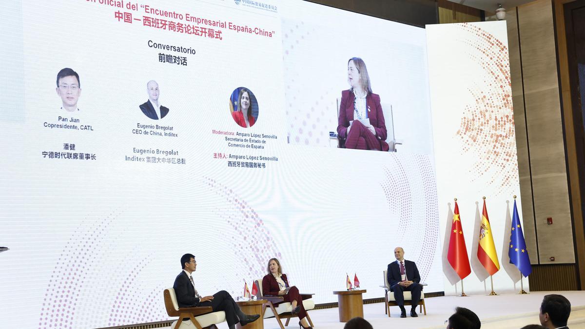 El responsable de Inditex en China, Eugenio Bregolat (d) junto con el copresidente de Contemporary Amperex Technology (CATL), Pan Jian (i) en un debate moderado por la secretaria de Estado de Comercio, María Amparo López Senovilla durante el Foro Empresarial España-China.
