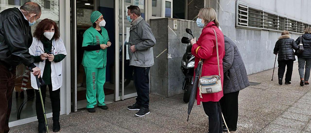 Pacientes a la entrada del centro de salud La Calzada II, en Gijón, ayer a la espera de vacunarse. | Marcos León