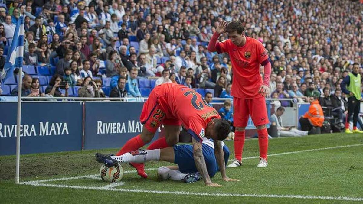 Alves lucha un balón con Moreno junto a unos de los córneres, ante la mirada de Messi, durante el partido entre el Espanyol y el Barcelona