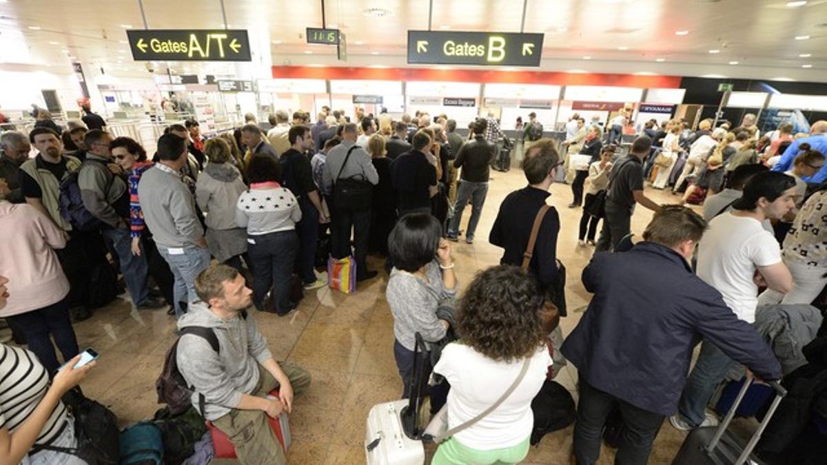 Decenas de pasajeros esperan en el vestíbulo del aeropuerto de Bruselas, tras el cierre del espacio aéreo.