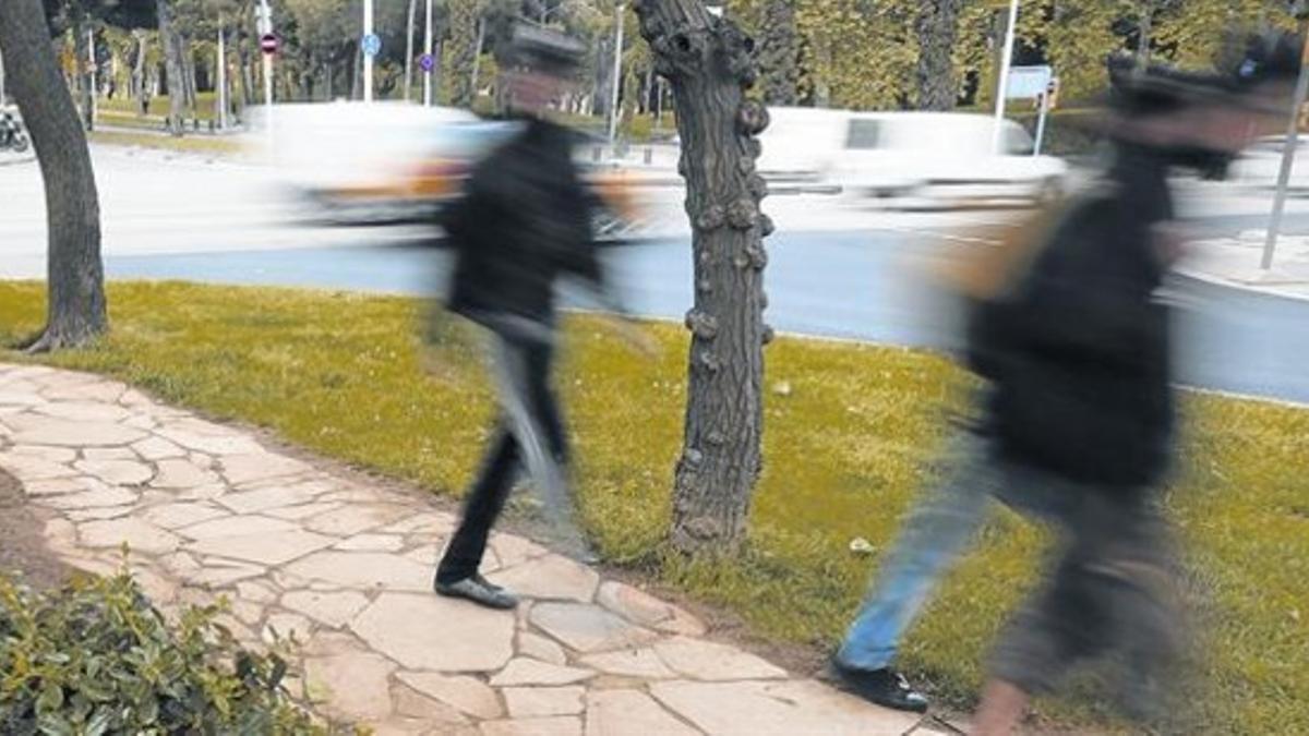 Unos peatones caminan por el atajo finalmente empedrado por el ayuntamineto, en la esquina de Marina y la avenida de Icària.