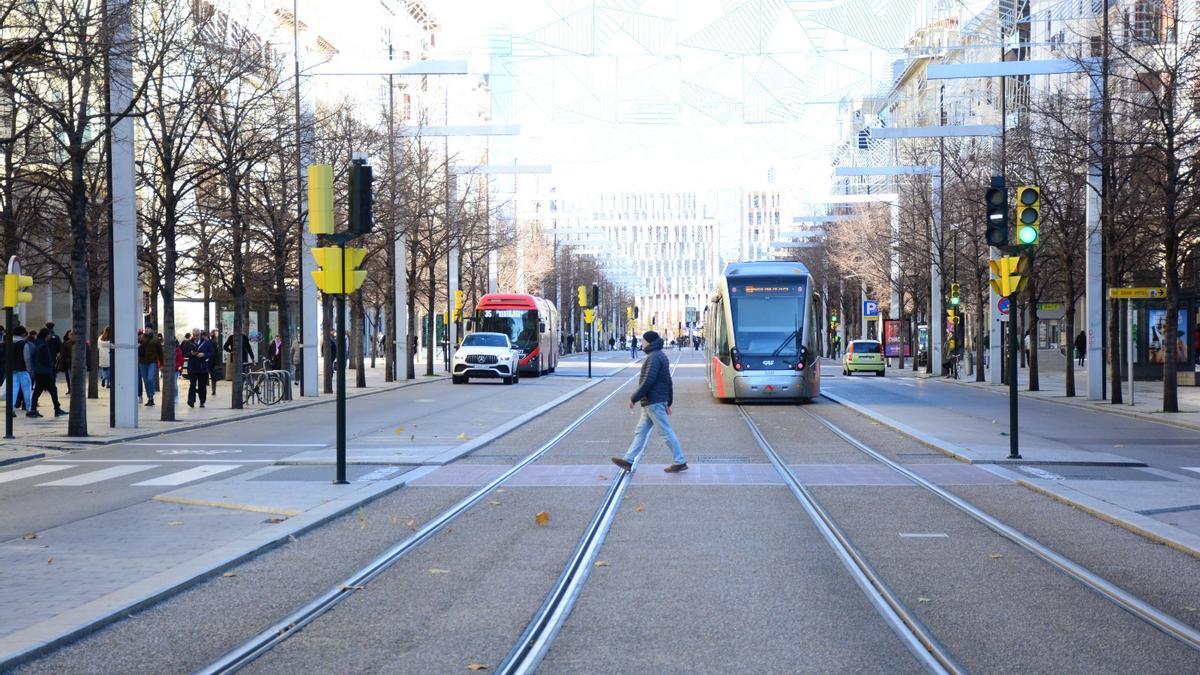 Un coche, un bus, un tranvía y un peatón circulan por el paseo Independencia de Zaragoza.