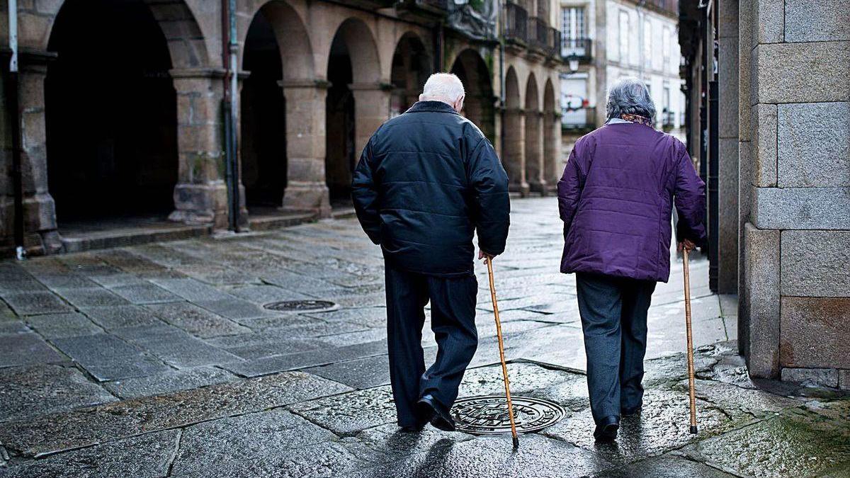 Dos personas mayores, caminando por el casco histórico de Ourense.