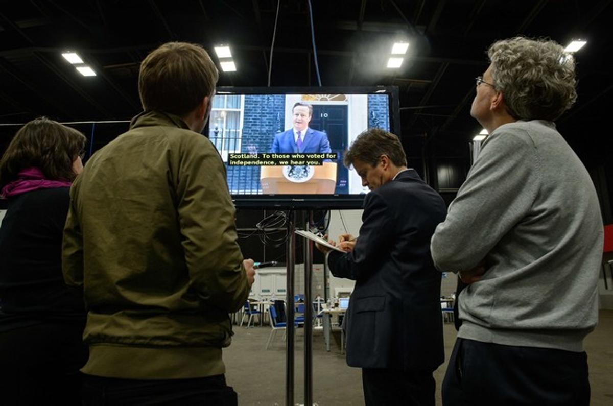 Los periodistas, siguiendo la rueda de prensa de David Cameron por la televisión.