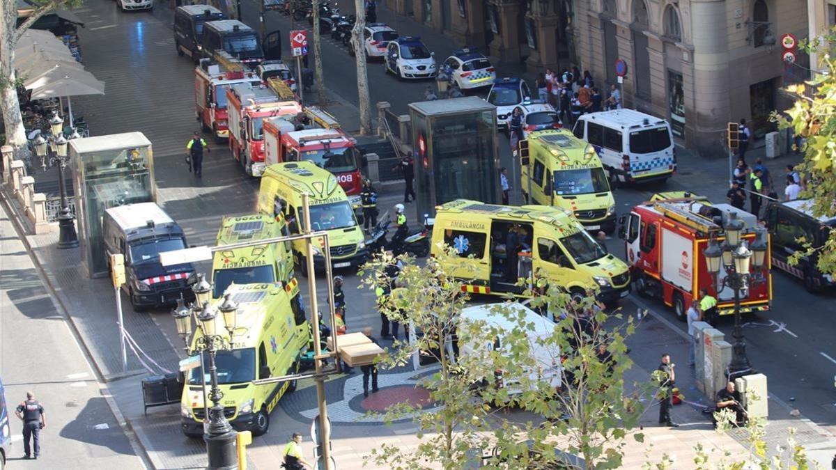 Servicios de emergencias y policías, junto a la furgoneta con la que se cometió el atentado en la Rambla de Barcelona.