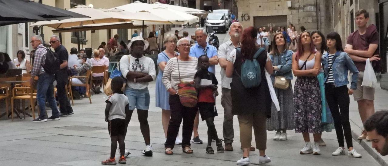 Un grupo de viajeros, ayer, con una guía turística, en la plaza de Santa Eufemia, en Ourense.