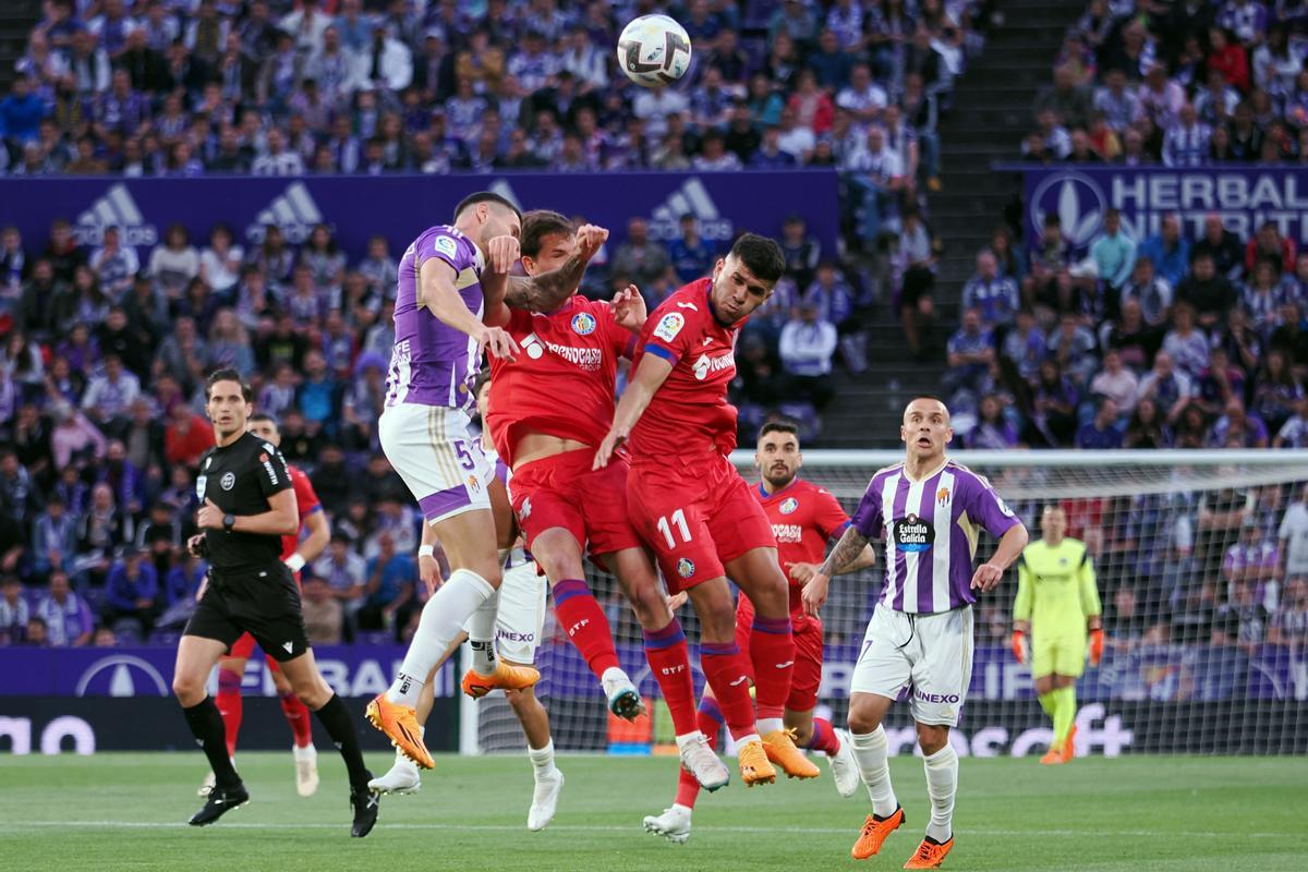 El defensa del Valladolid, Javi Sánchez, disputa el balón ante los jugadores del Getafe durante el encuentro correspondiente a la última jornada de primera división disputado en el estadio José Zorrilla, en la capital pucelana. EFE / R. García.