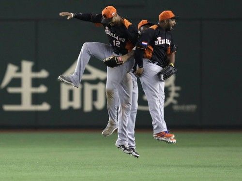 Netherlands' Balentien, Bernadina and Sams celebrate after defeating Cuba at the WBC second round game in Tokyo