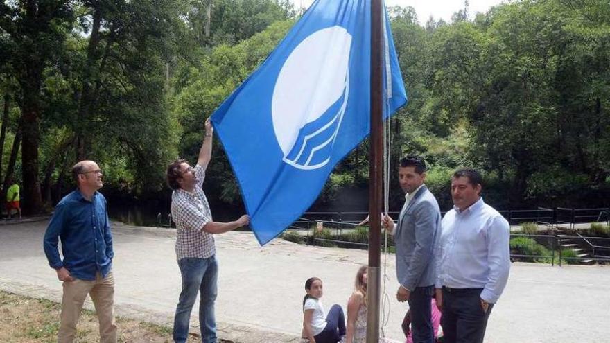 Andrés Díaz y el resto del equipo de gobierno, izando la bandera azul en A Calzada. // Rafa Vázquez