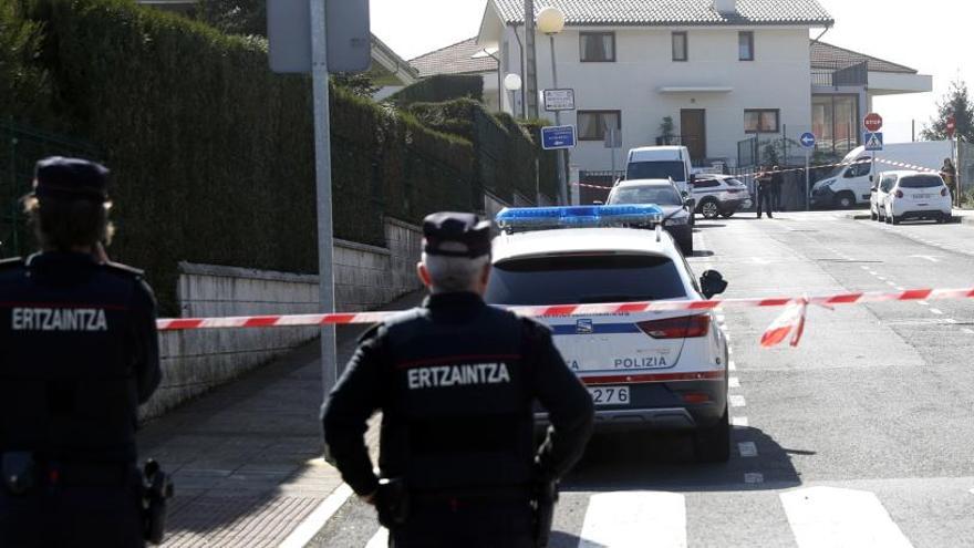 Dos agentes de la Ertzaintza junto a la vivienda donde se produjo el crimen.