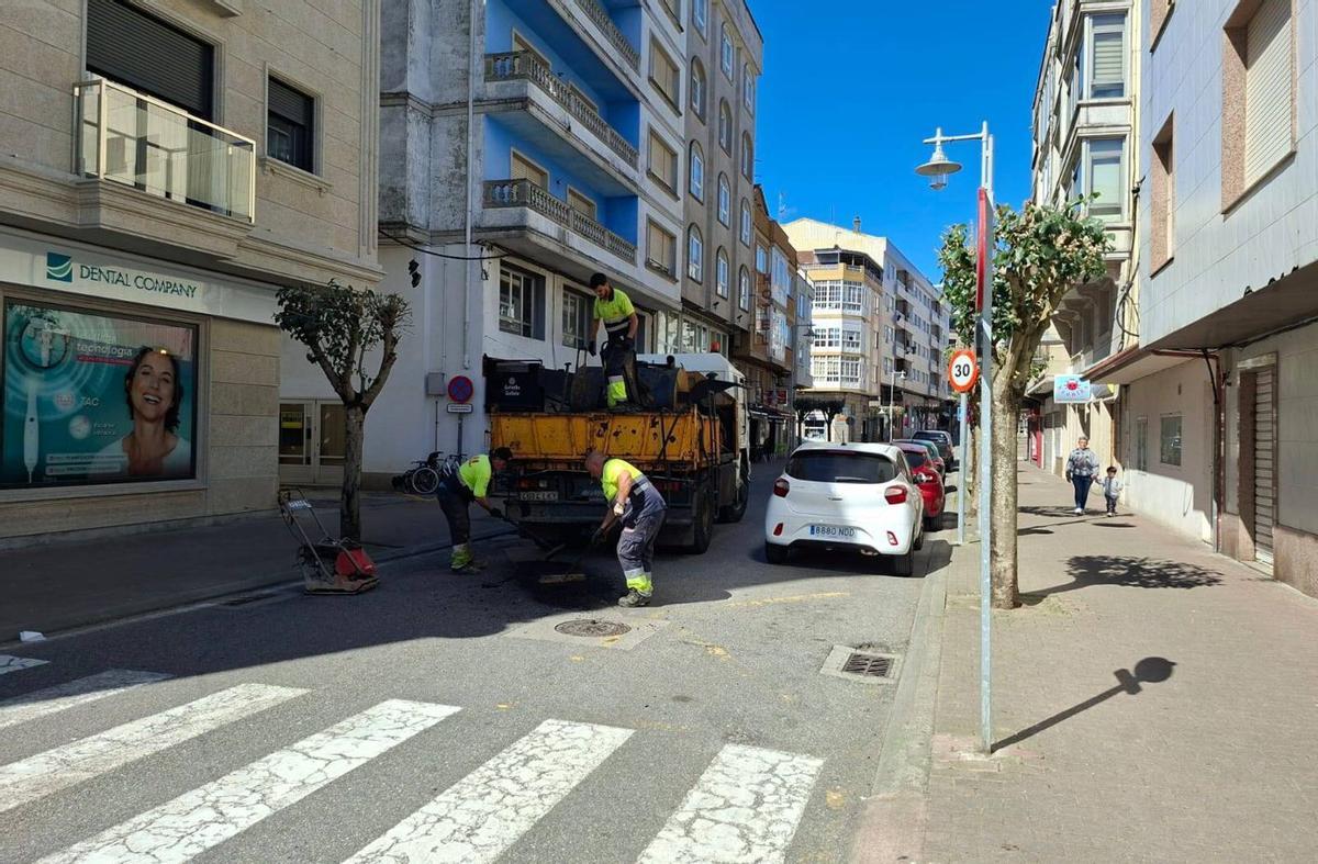 Operarios de la empresa Naron bachean en la avenida de Marín.