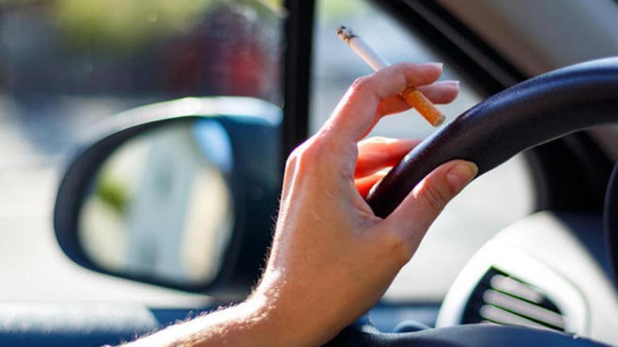 Una persona fumando en un coche.