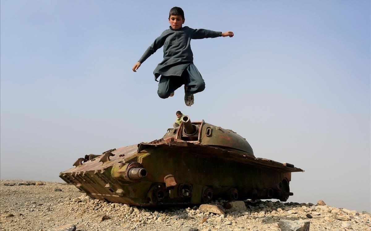 Un niño afgano salta desde los restos de un tanque de la era soviética en las afueras de Jalalabad, Afganistán.