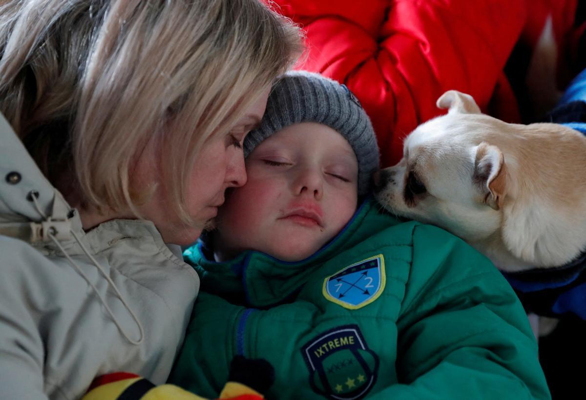 Una mujer abraza a su hijo, junto a su mascota, en un centro de acogida para refugiados en Beregsurany, en Hungría.