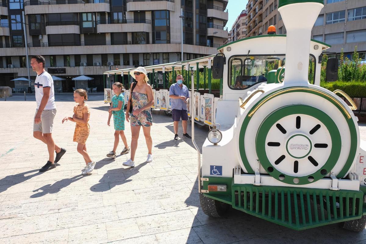Turistas extranjeros bajan del trenet turístico de Elche, en imagen de archivo