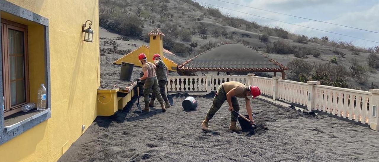 Los palmeros se esfuerzan en retirar la ceniza volcánica.