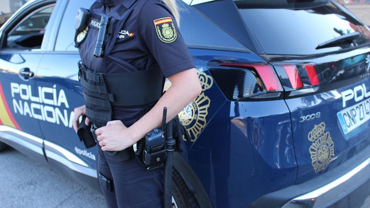 Una agente ante un vehículo de la Policia Nacional, en una imagen de archivo.