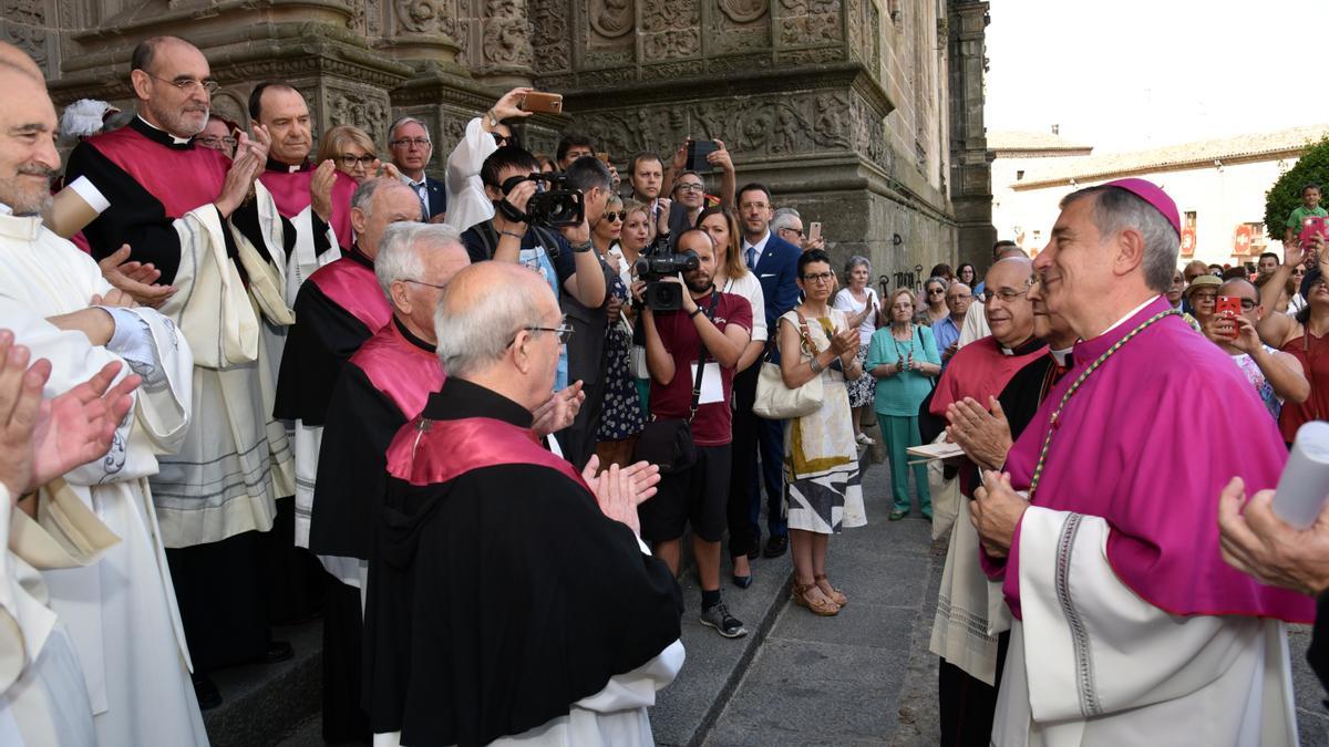 El obispo de Plasencia, José Luis Retana, aplaudido por miembros del clero ante la catedral.