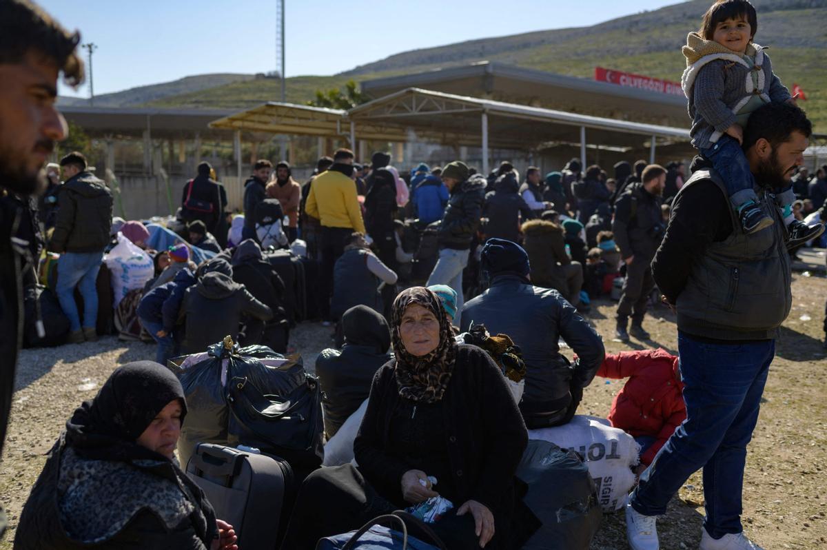 Los residentes sirios de la ciudad de Hatay esperan para cruzar la frontera entre Turquía y Siria después de que se vieron afectados por el terremoto de magnitud 7,8 que asoló la región hace casi dos semanas, en la puerta fronteriza de Cilvegozu