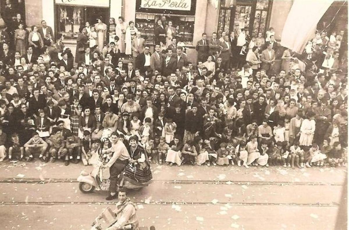 Una multitud, ante el escaparate de La Perla,en la calle Uría, durante un desfile del Día de América en Asturias.