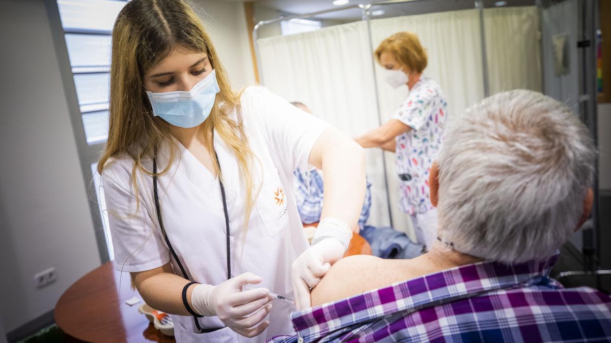 Dos sanitarias vacunan a dos vecinos del barrio del Actur, en Zaragoza, contra el covid, hace unos meses.