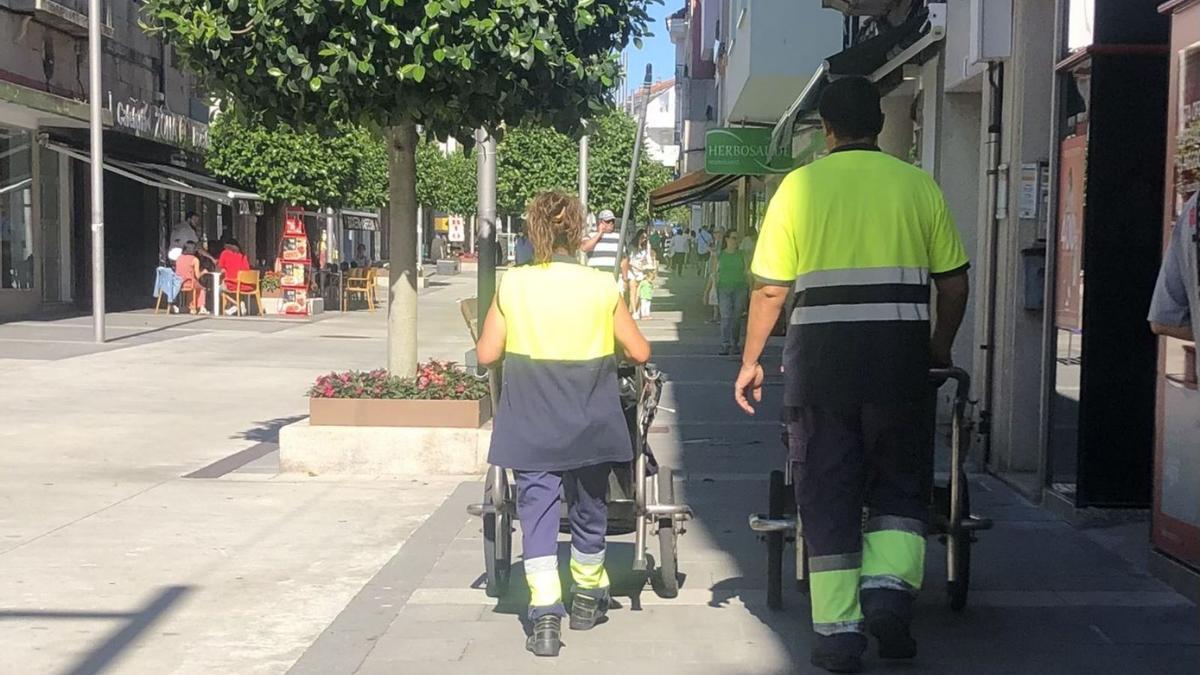 Dos barrenderos buscan la sombra en un día con los mercurios disparados
