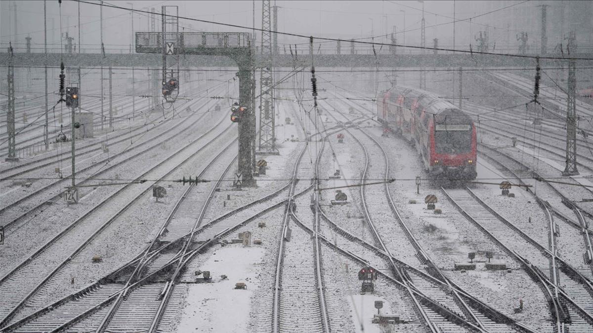 Un tren del operador alemán Deutsche Bahn DB se detiene en la estación principal en el sur de Alemania en Munich durante las nevadas. Se esperan fuertes nevadas el fin de semana.