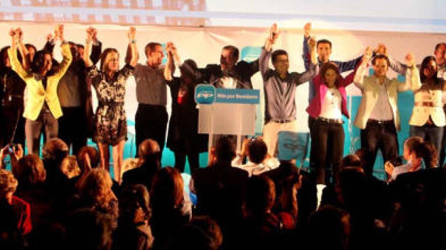 Fenoll, Castedo, los tres consellers y Clemente, junto al resto de componentes de la candidatura del PP en Benidorm, alzan las manos al público al finalizar el acto.