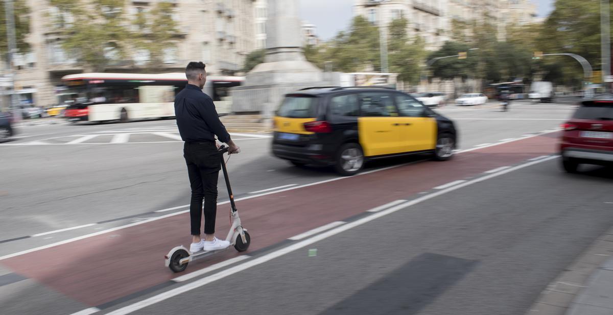 Un taxi y un turismo se cruzan delante de un patinador.