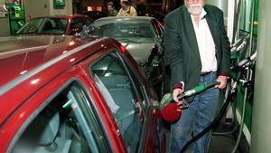 Un conductor rellena el tanque de carburante de su vehículo en una gasolinera.