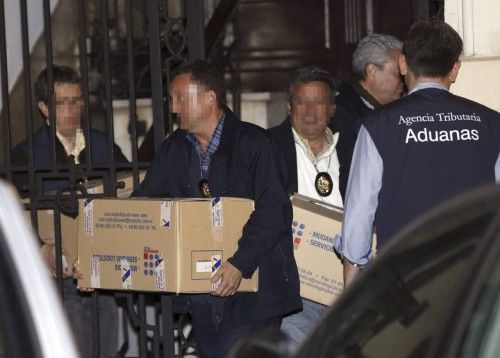 El exvicepresidente del Gobierno Rodrigo Rato (d) abandona su despacho cuatro horas después de que comenzara el registro por parte de los agentes de la Agencia Tributaria y de Aduanas, que han sacado una veintena de cajas con documentación.