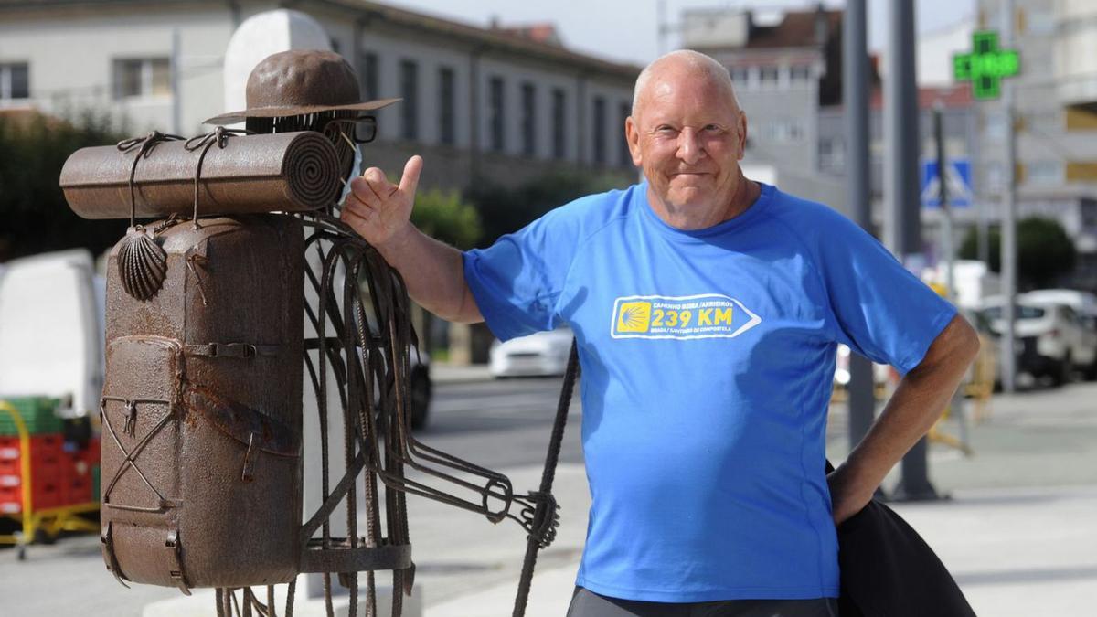 Peter posa junto a la escultura de un peregrino en la Praza do Concello, en A Estrada.   | //BERNABÉ/JAVIER LALÍN.