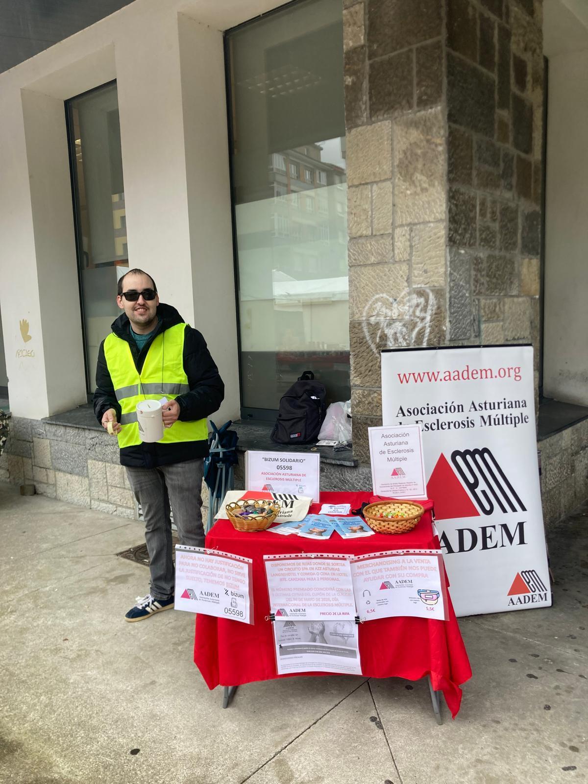 Un voluntario de la Asociación Asturiana de Esclerosis Múltiple, en el mercado semanal de El Entrego