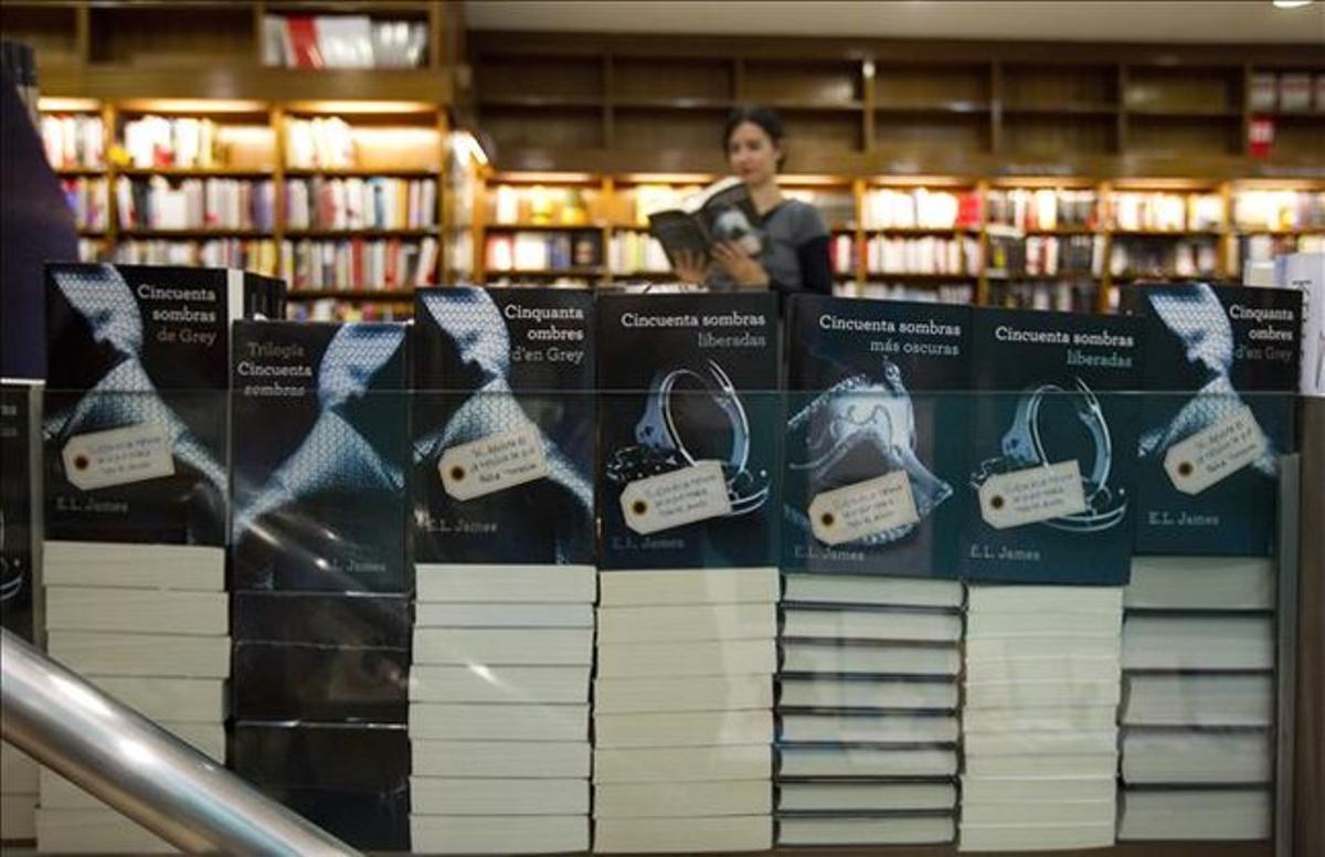 Los tres títulos de la trilogía de Grey, apilados en hileras en el expositor de la librería Alibri de Barcelona.