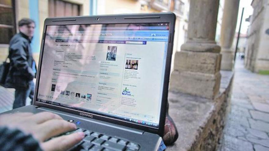 Un usuario de la red wifi en la calle de La Ferrería de Avilés.