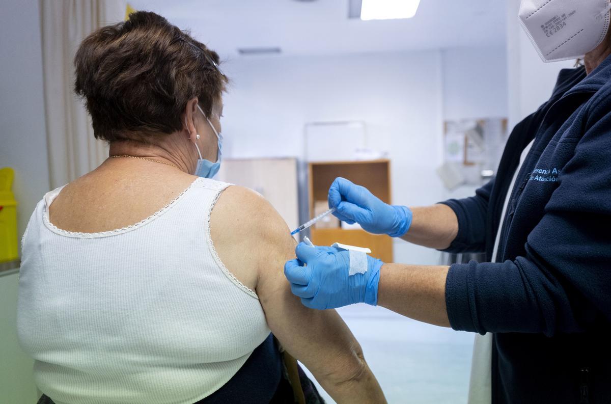 Archivo - Una mujer recibe la vacuna contra la gripe