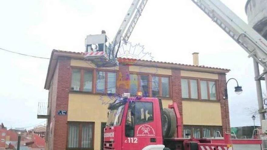 Los bomberos actuando en el tejado de un edificio municipal en la Mota.