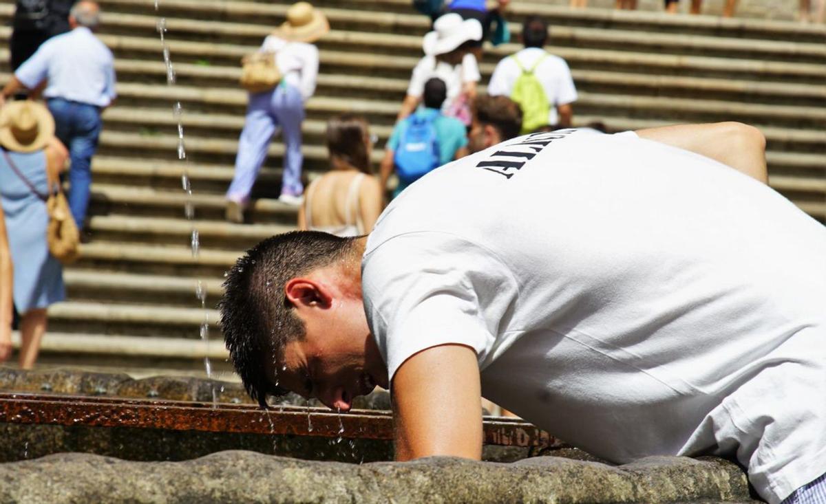 Un joven se refresca en la fuente de la Praza das Praterías /Jesús PRieto