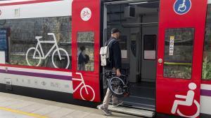 Un usuario sube al tren con una bicicleta plegable.