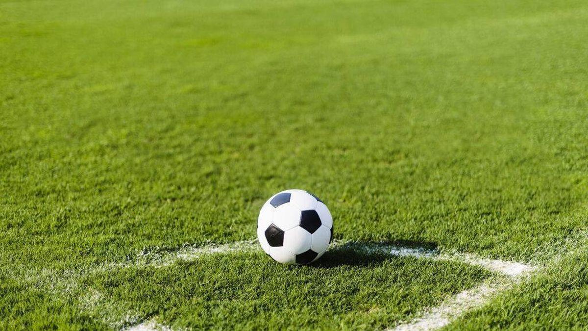 Un balón de fútbol en un campo de césped artificial.