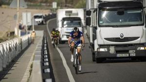 Dos camiones adelantan a unos ciclistas.