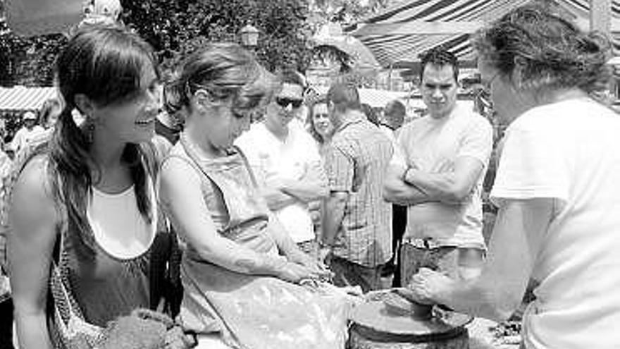 Una niña participa en un taller de alfarería en la Feria de artesanía.