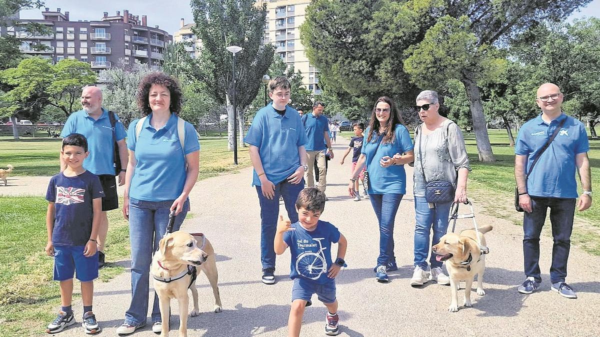 Acción solidaria del voluntariado corporativo de CaixaBank y sus familiares, acompañando en un paseo a zaragozanos con discapacidad visual