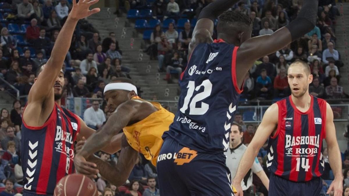 Rice, el base del Barça, pasa el balón entre Hanga y Diop, del Baskonia, en Vitoria.