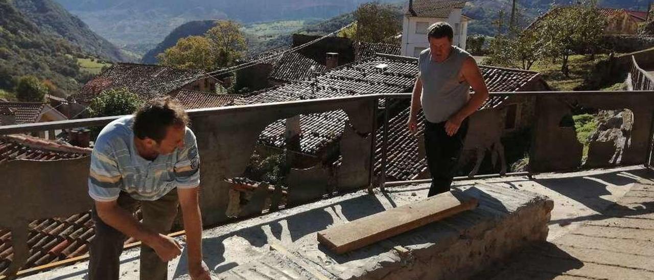 Felipe Niembro y Ramón Guerra ultiman la zona de La Venida de Les Vaques, una barandilla creada por el artista José Sahagún.